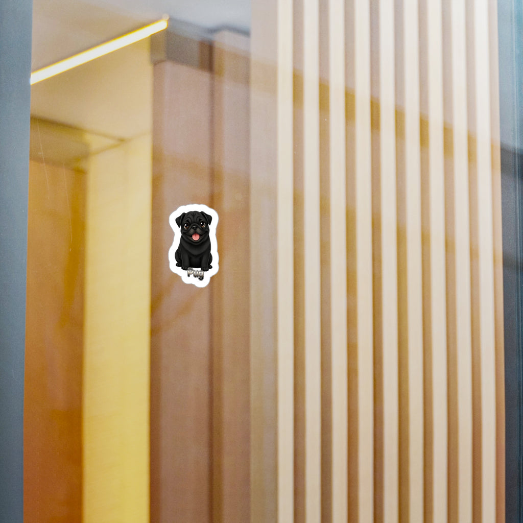 A small die-cut sticker of a black dog with a red tongue, shown on a glass door or window with a modern interior background of vertical wooden slats.