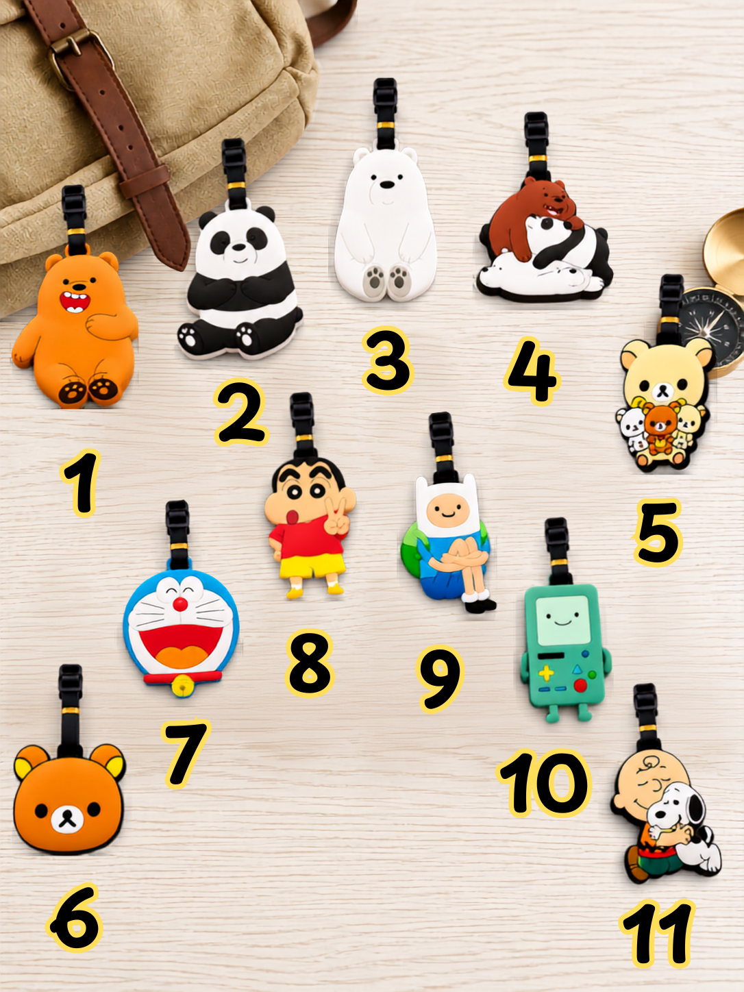 Collection of eleven numbered cartoon character bear luggage tags on a wooden surface